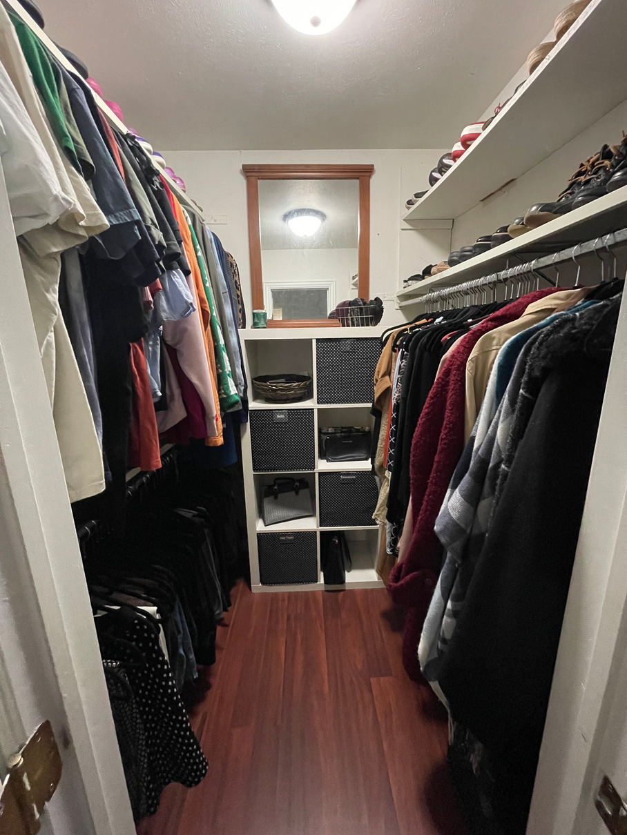 a decluttered and organized walk-in closet with many clothes and shoes