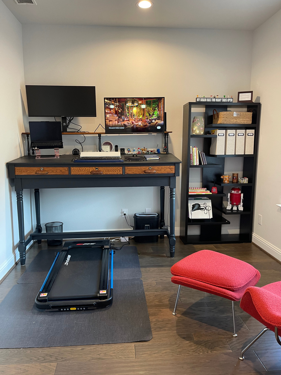 a decluttered and organized home office with a treadmill, desk and chair